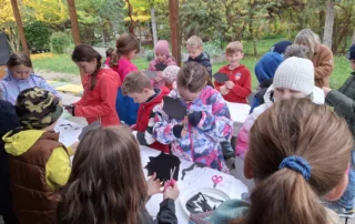 Kinder der Klasse 3bB basteln im Grünen Klassenzimmer Igel aus schwarzem Papier